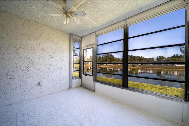 unfurnished sunroom featuring ceiling fan and a water view