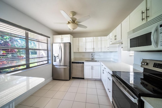 kitchen with ceiling fan, light countertops, appliances with stainless steel finishes, white cabinetry, and a sink