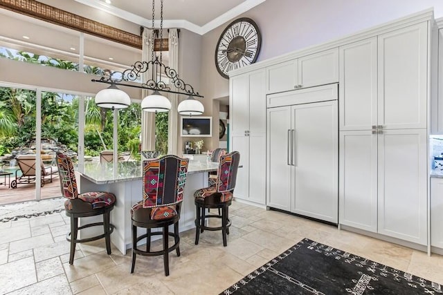 404 Mariner Dr, Jupiter, FL 33477 - dining room with crown molding, a towering ceiling, stone tile flooring, and a chandelier