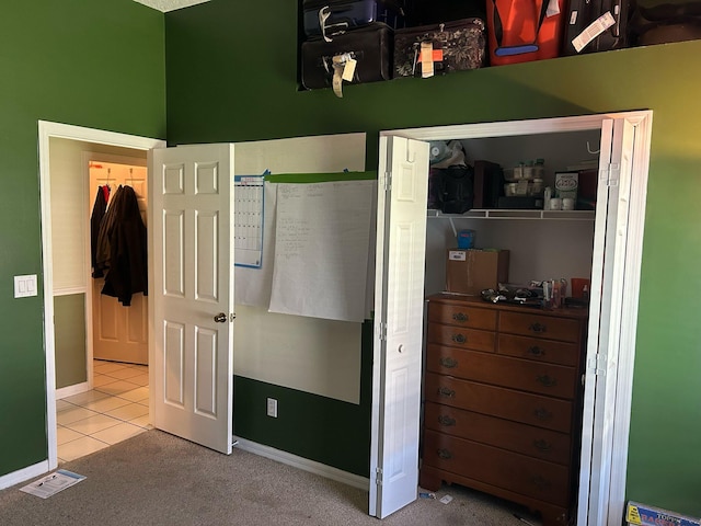 carpeted bedroom featuring visible vents, baseboards, a closet, and tile patterned flooring