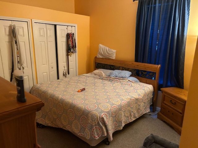 bedroom featuring carpet and multiple closets