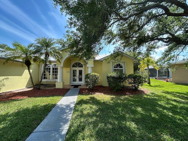 view of front of home with french doors, a front yard, and stucco siding