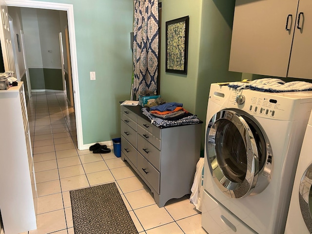 laundry room with independent washer and dryer, light tile patterned flooring, cabinet space, and baseboards