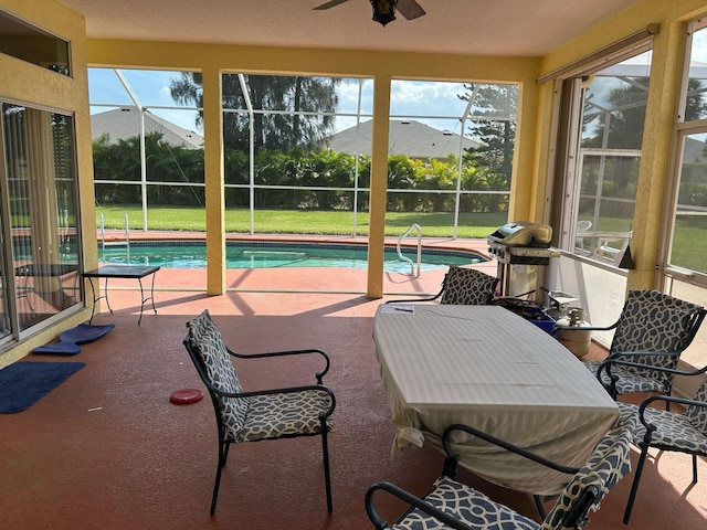 sunroom / solarium with ceiling fan, a healthy amount of sunlight, and a pool