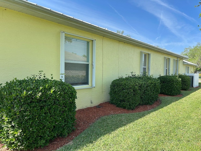 view of property exterior featuring stucco siding and a lawn