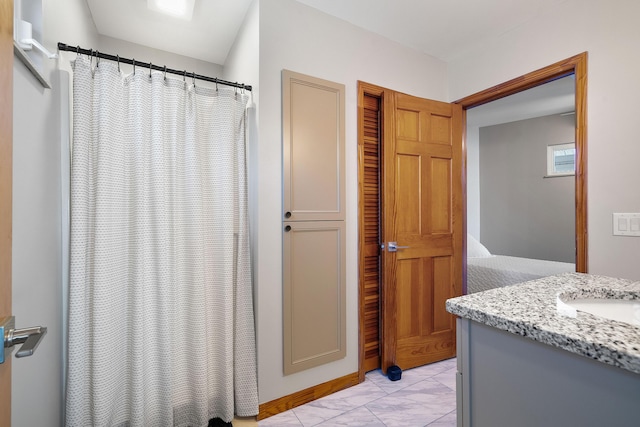 full bathroom featuring marble finish floor and vanity