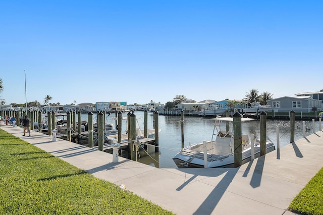 view of dock featuring a residential view, a water view, and a lawn