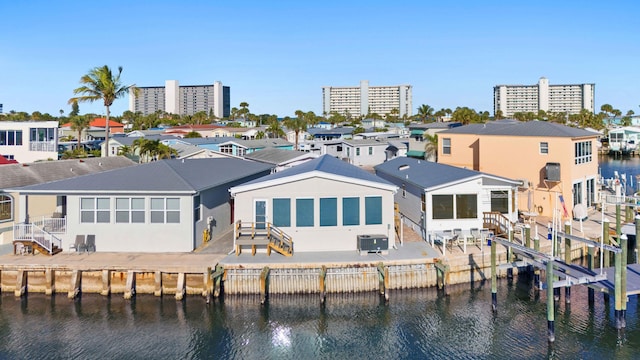 back of house featuring a residential view, a patio, central AC unit, and a water view