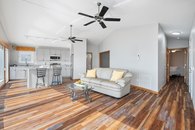 living room featuring visible vents, wood finished floors, a ceiling fan, and vaulted ceiling