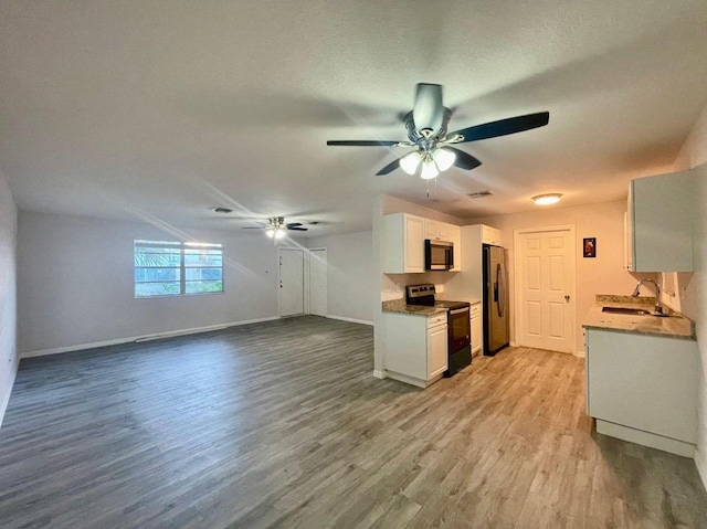 kitchen with ceiling fan, light wood-style flooring, white cabinets, stainless steel appliances, and a sink