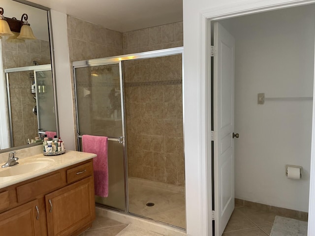 bathroom with tile patterned floors, baseboards, vanity, and a shower stall