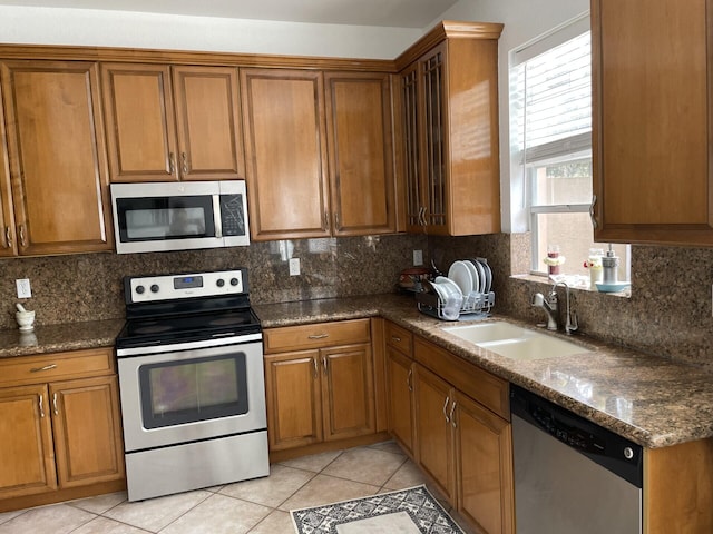 kitchen with decorative backsplash, brown cabinets, stainless steel appliances, and a sink