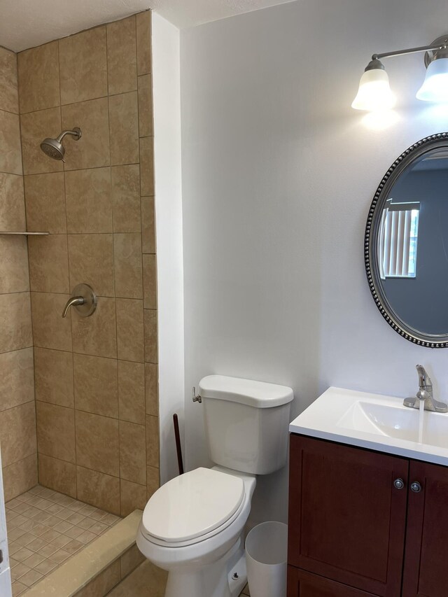 bathroom with a stall shower, toilet, and vanity