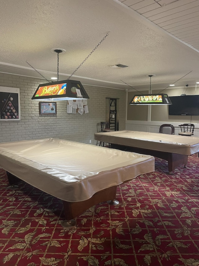 recreation room featuring visible vents, brick wall, carpet flooring, a textured ceiling, and billiards