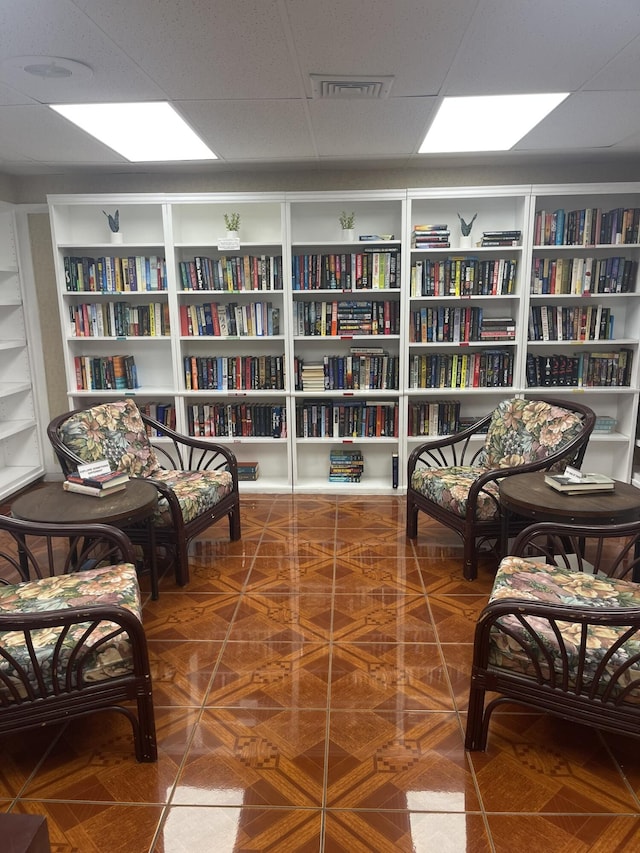 living area with visible vents and bookshelves