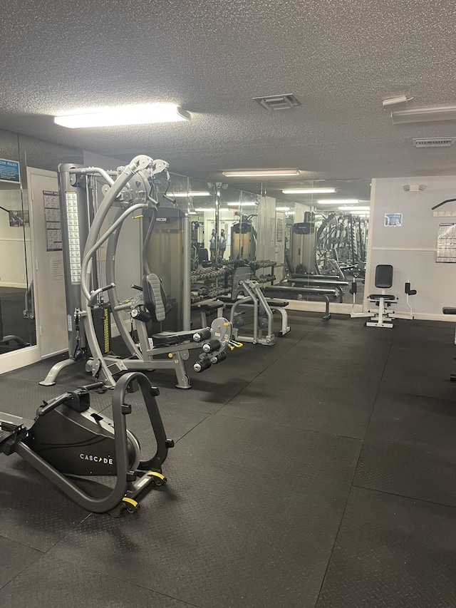 workout area featuring visible vents and a textured ceiling