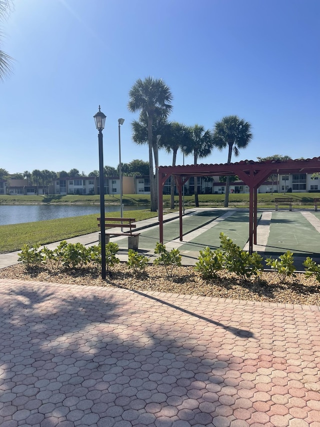 view of property's community featuring shuffleboard and a water view