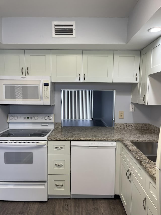 kitchen featuring visible vents, stone counters, dark wood-style floors, white appliances, and white cabinetry