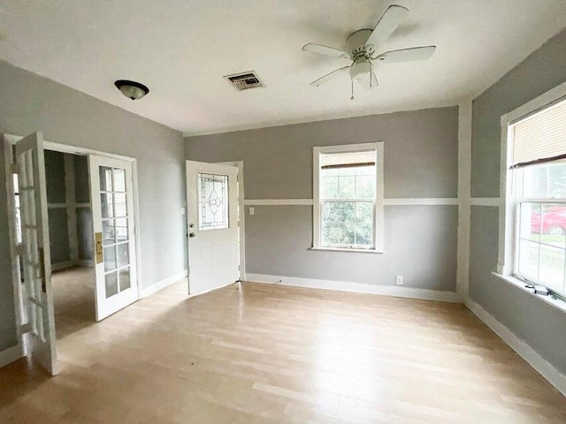 unfurnished room featuring visible vents, baseboards, light wood-style floors, and a ceiling fan