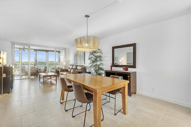 dining room with a wall of windows, baseboards, and light tile patterned floors