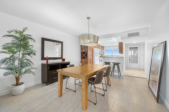 dining space featuring light tile patterned floors, baseboards, and visible vents