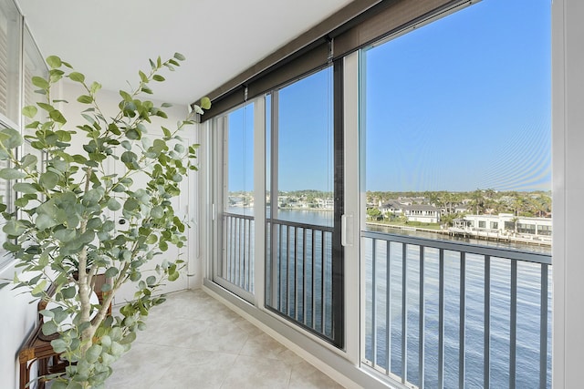 sunroom featuring a wealth of natural light and a water view