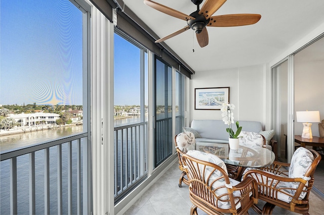 sunroom with a water view and ceiling fan