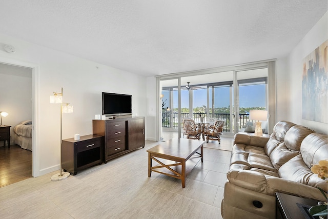 living area with expansive windows, baseboards, and a textured ceiling