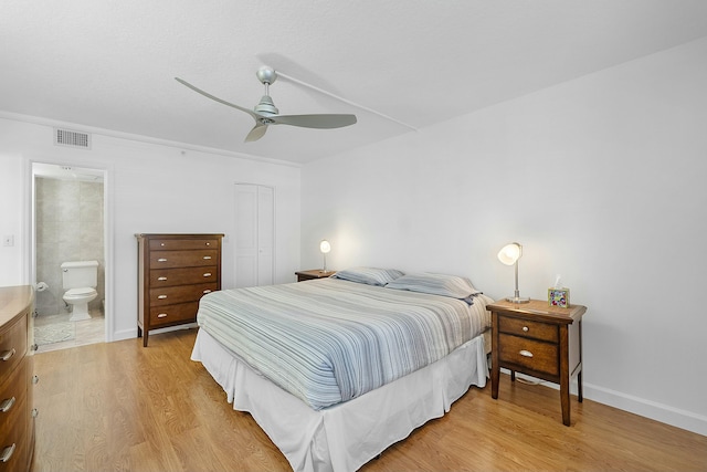 bedroom with visible vents, light wood-style flooring, connected bathroom, a closet, and baseboards