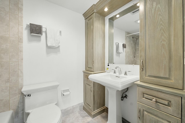 bathroom with visible vents, toilet, baseboards, and a sink