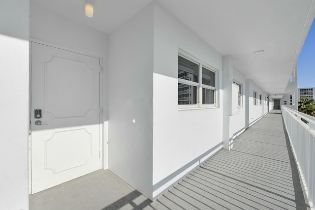 view of exterior entry with stucco siding and a balcony