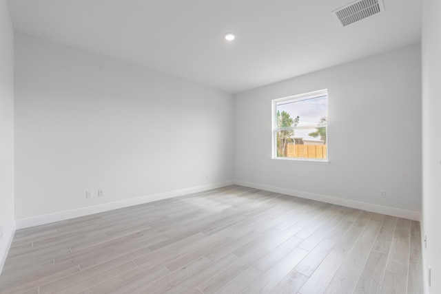 spare room with visible vents, baseboards, and light wood-style flooring