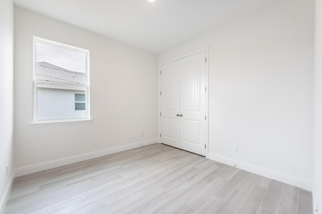 unfurnished room featuring baseboards and light wood finished floors