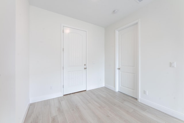 empty room featuring light wood-style flooring and baseboards