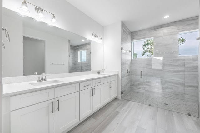 full bath featuring double vanity, recessed lighting, a stall shower, and a sink