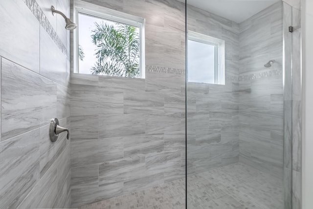 bathroom with a healthy amount of sunlight and tiled shower