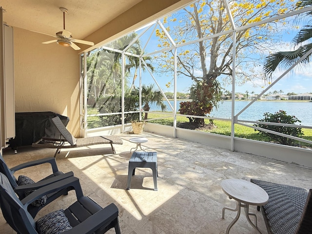 view of patio / terrace with glass enclosure, a ceiling fan, and a water view