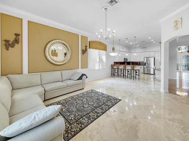 living area with visible vents, arched walkways, ornamental molding, a notable chandelier, and marble finish floor