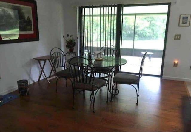 dining space with baseboards and wood finished floors