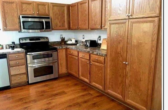 kitchen featuring brown cabinetry, wood finished floors, and stainless steel appliances