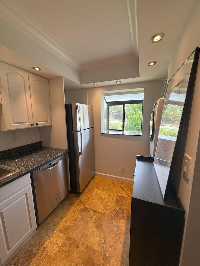 kitchen featuring ornamental molding, a tray ceiling, recessed lighting, appliances with stainless steel finishes, and white cabinets
