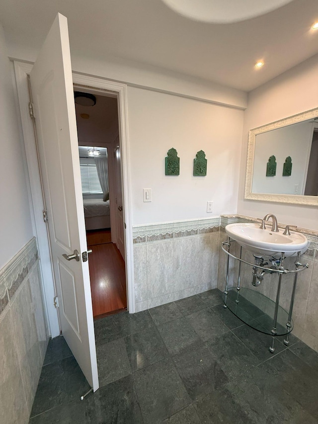 bathroom featuring a sink, tile walls, and wainscoting