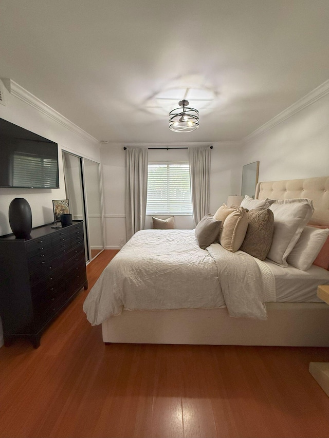 bedroom featuring wood finished floors, a closet, and ornamental molding