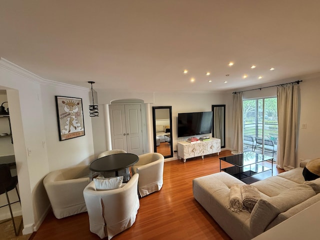 living area with crown molding, recessed lighting, and wood finished floors