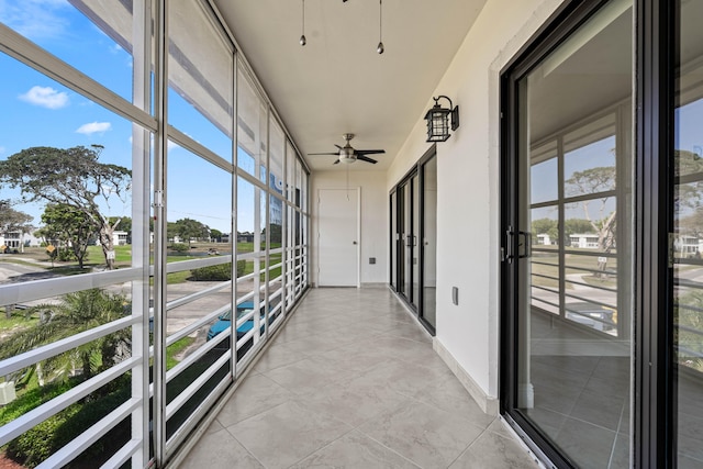 unfurnished sunroom featuring ceiling fan