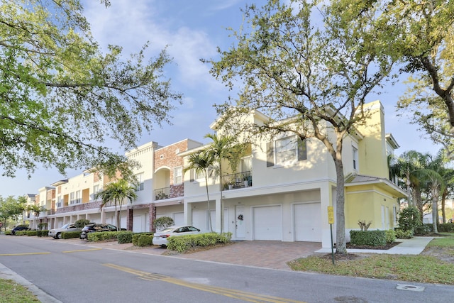 view of property featuring a garage, a residential view, and driveway