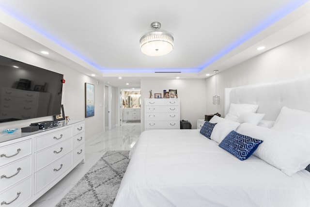 bedroom with ensuite bath, a raised ceiling, recessed lighting, and marble finish floor