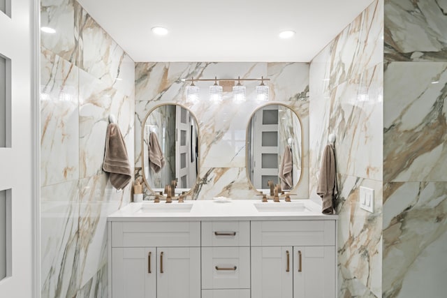 full bath featuring tile walls, recessed lighting, double vanity, and a sink