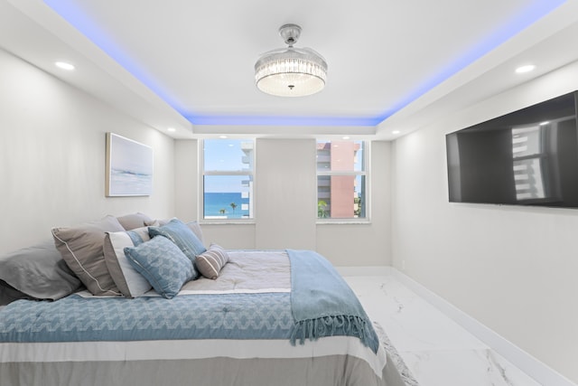 bedroom featuring a tray ceiling, recessed lighting, baseboards, and marble finish floor