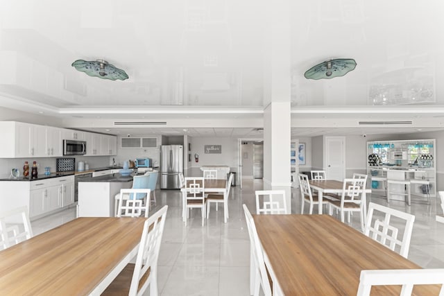 dining area featuring light tile patterned floors and a toaster